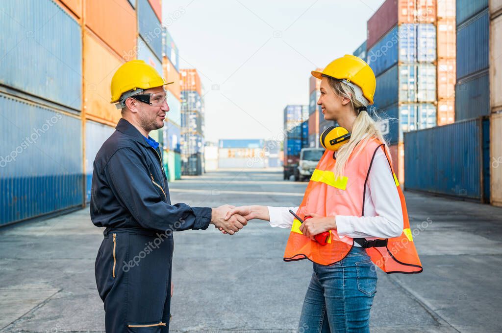 Happy dealing shaking hands two foreman man & woman worker working checking at Container cargo harbor to loading containers. Dock male and female staff business Logistics import export shipping concept.