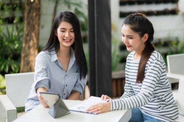 İki güzel Asyalı kadın sabahları evden çalışıyor. Bilgisayarla çalışan Asyalı genç bir kadın evde kalıyor..