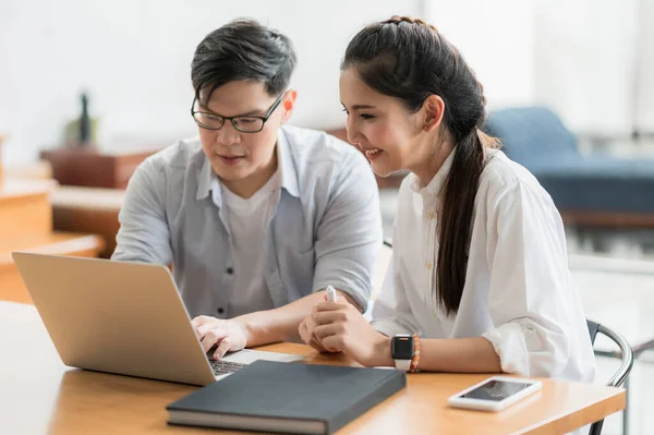 Asian business people man and woman conference talking and working with laptop together. Young couple work at home.