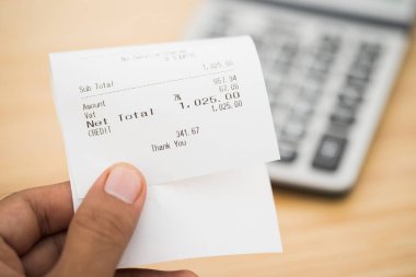 İş adamı aylık ödeme faturalarını elinde tutuyor. Mali satın alma giderleri gelir harcamaları.