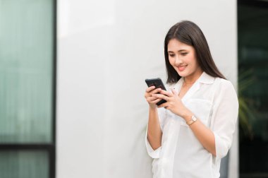 Genç Asyalı güzel kadınlar akıllı telefon kullanıyor. .