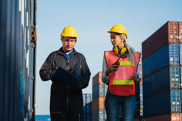 Two foreman man & woman worker working checking at Container cargo harbor to loading containers. Dock male and female staff business Logistics import export shipping concept.