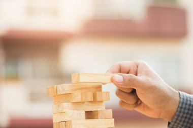 Erkek el ele tutuşup düzenleme yapın ya da blok tahtası oyununu oynayın ve istifleyin. İş yatırımlarının büyümesi ve iflas kavramı.