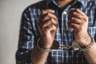 Elleri kelepçeli bir mahkum hapiste. Kelepçeli Elleri Kapat.