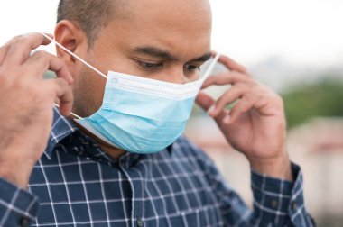 Korunaklı yüz maskesi takan Asyalı genç adamı Coronavirus 'a karşı kapatın..