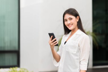 Genç Asyalı güzel kadınlar akıllı telefon kullanıyor. .