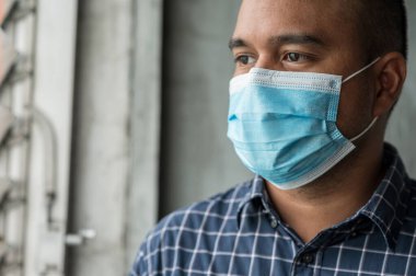 Korunaklı yüz maskesi takan Asyalı genç adamı Coronavirus 'a karşı kapatın..