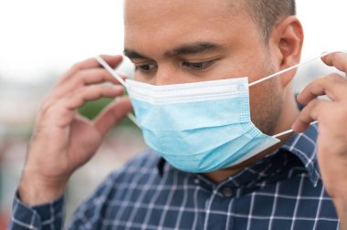 Korunaklı yüz maskesi takan Asyalı genç adamı Coronavirus 'a karşı kapatın..