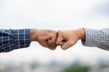 İki iş adamı başarılı olmak için yumruk tokuşturuyor.