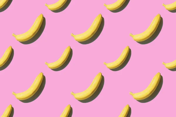 Banana pattern with shadow on pink background