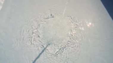 Şehrin ortasındaki bir evin tepesine, şişme bir havuza düşen su jeti..