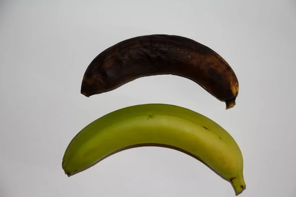 Duas bananas para comparação: uma madura, preta, marrom e esteticamente agradável e a outra apta para comer e cozinhar . — Fotografia de Stock