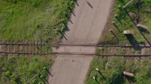 A travessia ferroviária na paisagem rural. Visão aérea de cima para baixo . — Vídeo de Stock