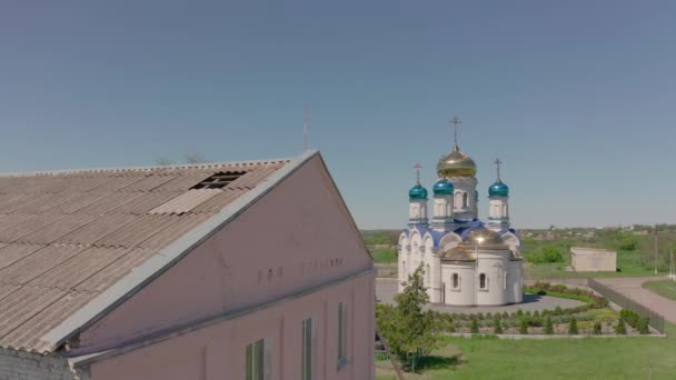 Casa soviética de la cultura y una iglesia en un pueblo ucraniano - Vista aérea — Vídeos de Stock