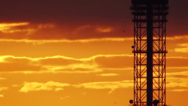 Torre de TV na silhueta do pôr do sol, belo céu de fogo laranja — Vídeo de Stock