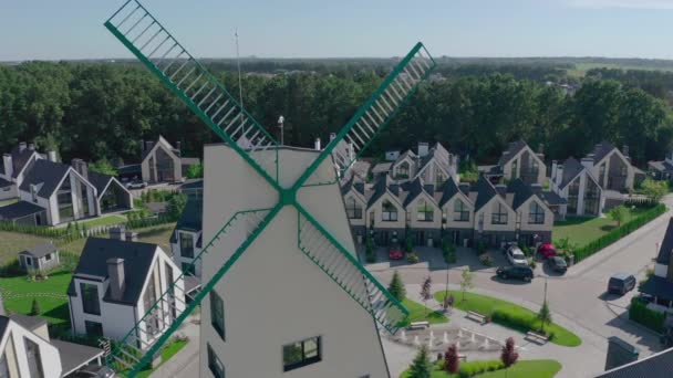Коттеджный городок в пригороде в окружении дубового леса, большой декоративной ветряной мельницы — стоковое видео
