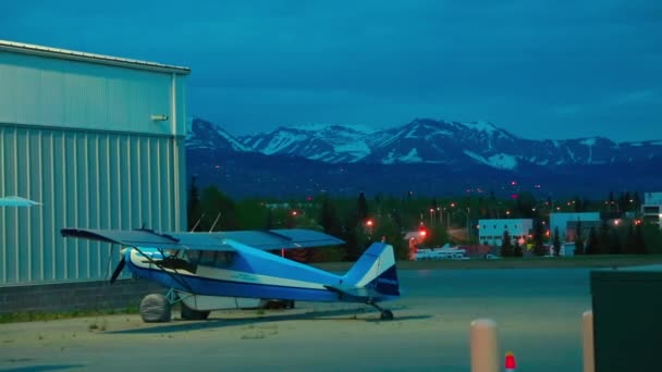 Lekkie samoloty jednosilnikowe i samochód zaparkowany w nocy na lotnisku Alaska — Wideo stockowe
