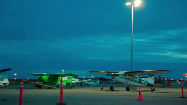 Aviones ligeros monomotor y coche estacionado la noche en el aeropuerto de Alaska — Vídeos de Stock