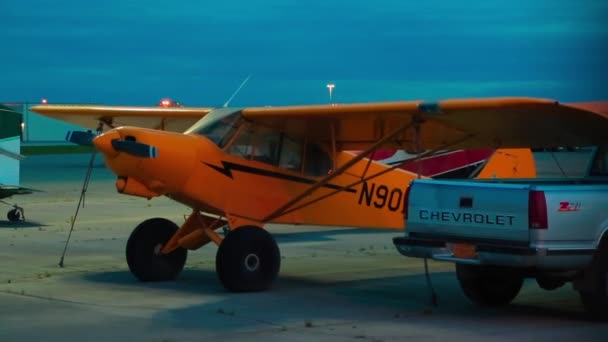Lekkie samoloty jednosilnikowe i samochód zaparkowany w nocy na lotnisku Alaska — Wideo stockowe
