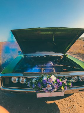 Bozuk düğün retro arabası, açık kaput ve mavi duman motordan geliyor.