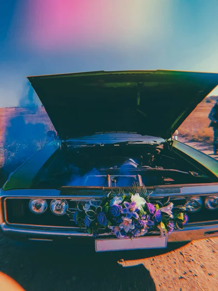 broken wedding retro car, open hood and blue smoke coming from the engine.