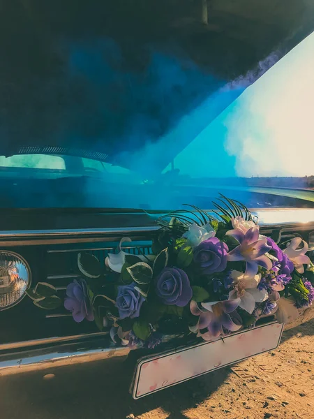Bozuk düğün retro arabası, açık kaput ve mavi duman motordan geliyor.
