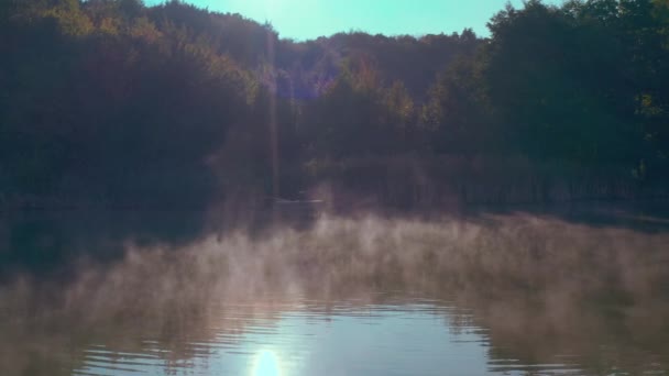 The water evaporates and floats above the water in the morning sun. — Stock Video