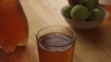 Buz küpleri ahşap masada elma sodası sıçrıyor.