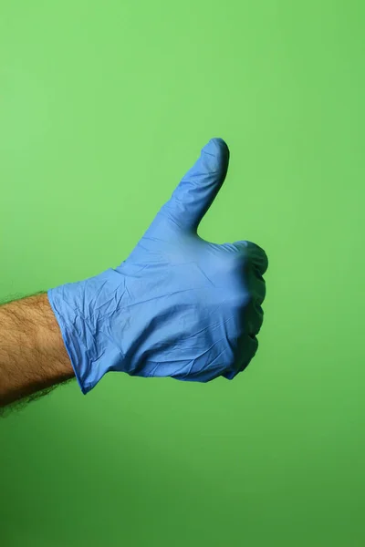 Hand Medical Glove Shows Thumb Gesture Green Background — Stock Photo, Image