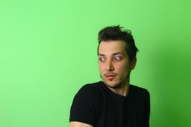 Açık yeşil arka planda etkileyici bir genç adam ya da adam. Korku hissi.