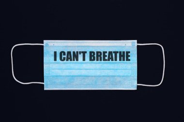 The inscription I CAN'T BREATHE on a medical surgical mask. Black background clipart