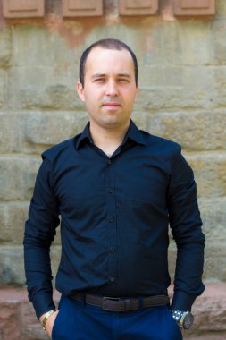 Yazı veya metin koymak için fotokopi alanı olan eski bir taş binanın arka planındaki genç adam..