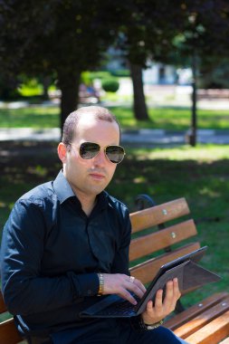 Laptop tabletli genç bir adam bir yazı ya da metin yerleştirmek için kopyalama alanı olan kentsel bir ortamda çalışır..