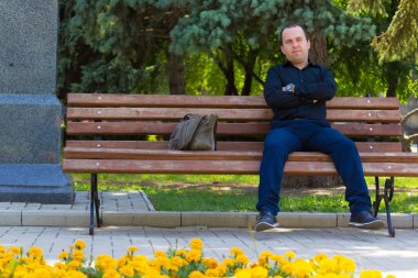 Yazı veya metin yerleştirmek için kopyalama alanı olan şehir ortamında bir bankta dinlenen bir adamın portresi.