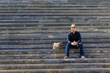 Bir yaz günü şehir ortamında bir adamın portresi basamaklarda bir yazı ya da yazı koymak için fotokopi alanı ile birlikte..