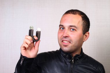 Manyetik paralarla mıknatıs tutan deri ceketli bir adam. Başlangıç konsepti, ilk para ve bir iş kurma