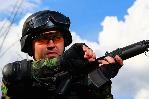 The special forces soldier charges the cartridge in the chamber of the assault rifle.