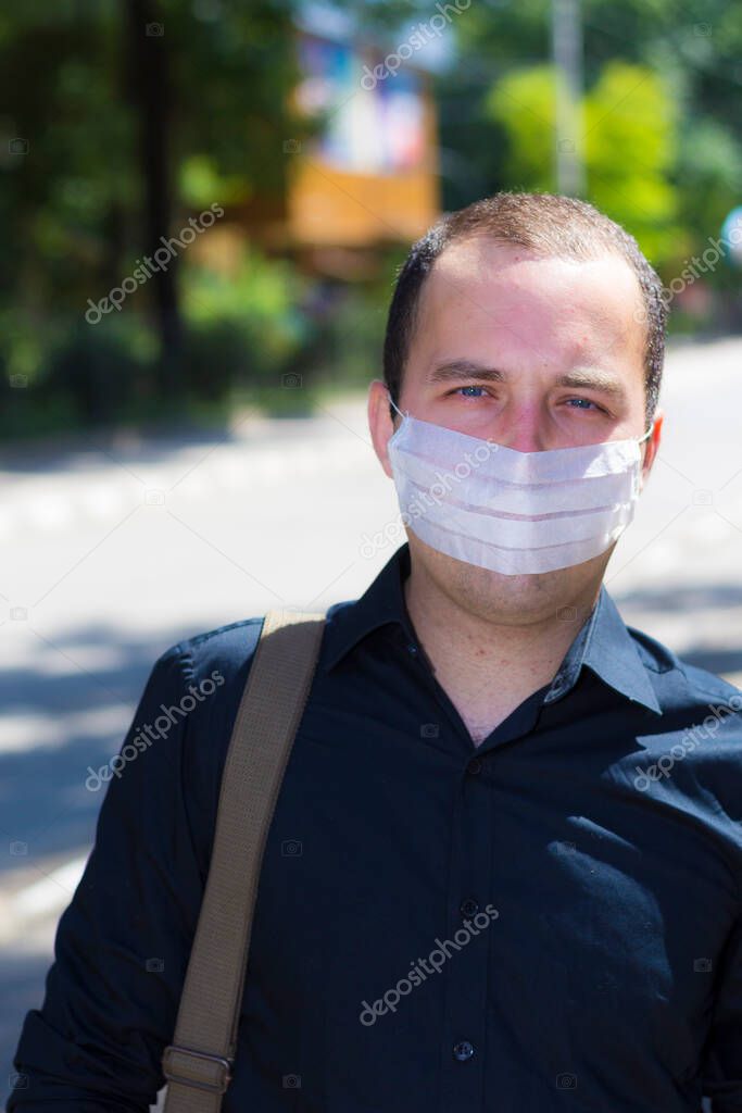 Young man in a medical mask with copy space to place an inscription or text. The concept of urban air pollution