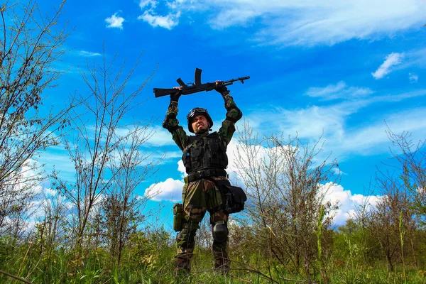 一名特种部队士兵头顶着机枪 带着蓝天绿叶 在美丽的自然景观背景下欢庆胜利 — 图库照片