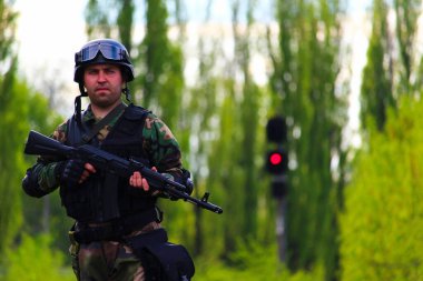 Kırmızı ışığı olan bulanık bir arka planda tüfeği olan bir asker. Yaşam biçimi