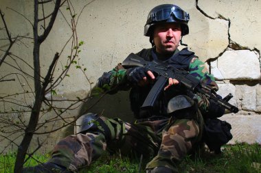 Çatlak bir duvarın arka planında çökmüş alçılı, yumuşak bir askerin dramatik portresi. Yaşam biçimi