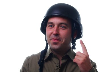 Beyaz arka planda yüzünde gülümseme olan askeri kasklı bir adam parmağını kaldırır. Mutluluk ve neşe duygusu. Savaşın ilk kuralı