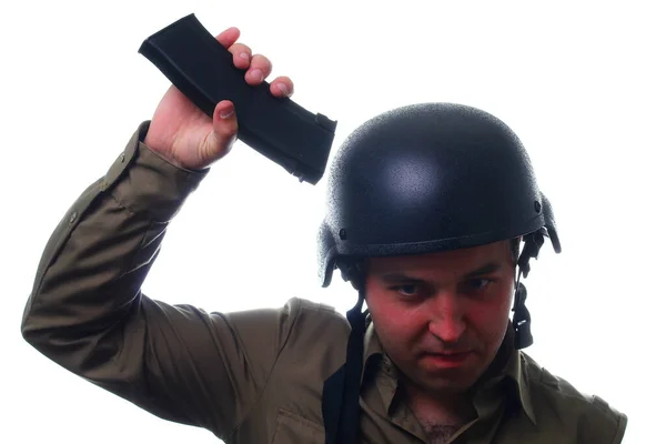 男は白い背景にヘルメットの上にライフルクリップをノックします 武器のサンドブラスターの概念 — ストック写真