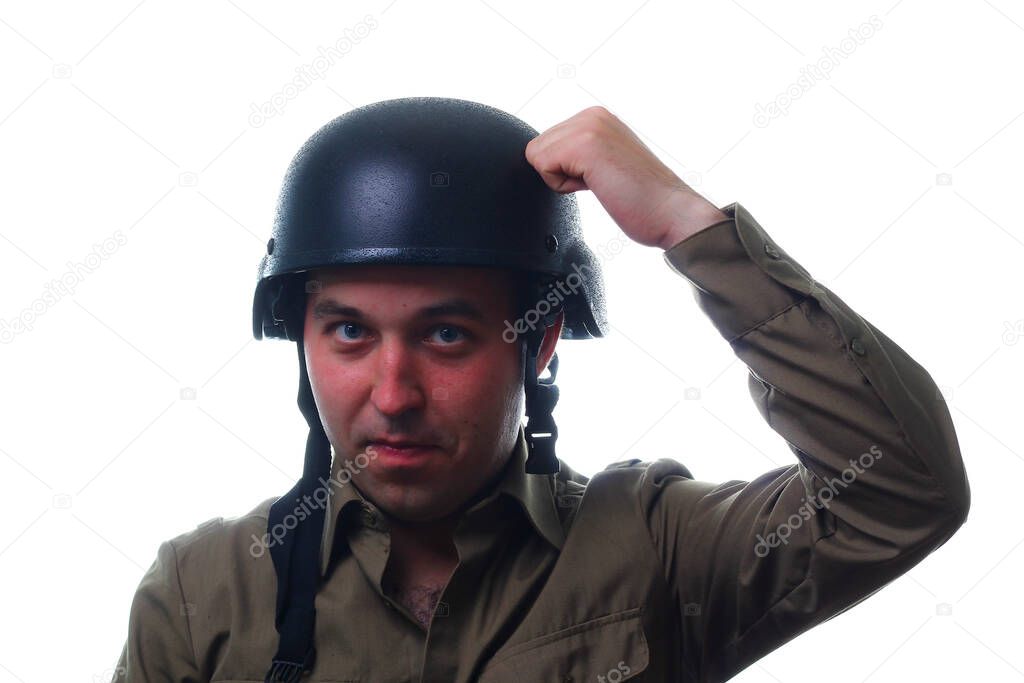 A man bangs his fist on a helmet on his head against a white background. The concept of human stupidity