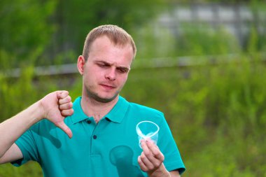 Mars 'ın yeşil tişörtlü gönüllü bir adam buruşmuş plastik bardakta baş parmak hareketi gösteriyor. Plastik olmayan kavramı