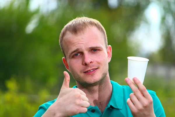 火星の緑のTシャツの若い男は 環境に優しい紙使い捨て料理やカップだけを使用することを促す — ストック写真