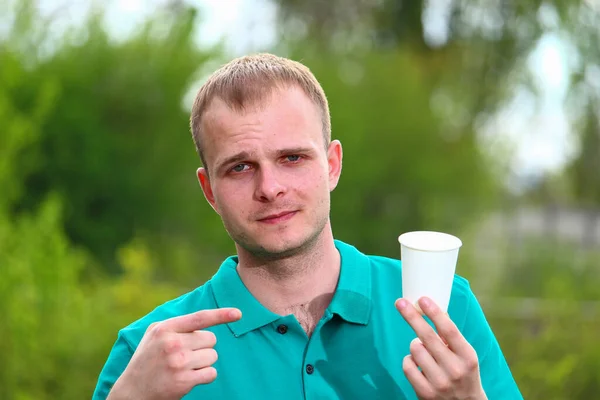 Ung Man Marrs Grön Shirt Visar Sitt Finger Engångs Pappersmugg — Stockfoto