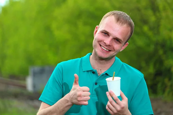 Marrs Yeşil Tişörtlü Genç Adam Elinde Bir Kağıt Bardak Tutuyor — Stok fotoğraf