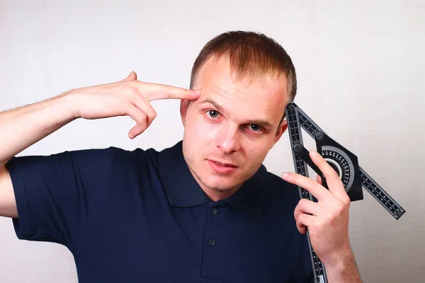 Joven Ingeniero Con Una Clásica Camiseta Azul Con Cuello Sostiene — Foto de Stock