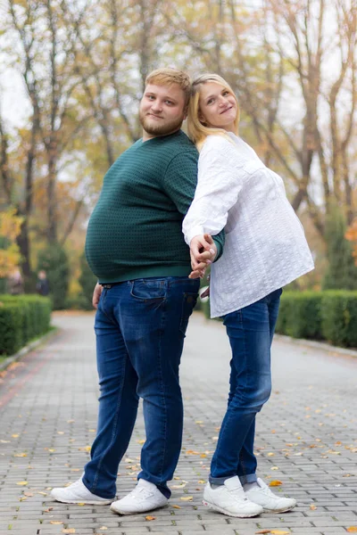 怀孕的妻子和丈夫背对着对方站在公园里 笑着说 — 图库照片